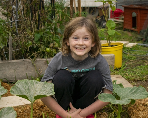 Hugo grins in his vegie patch